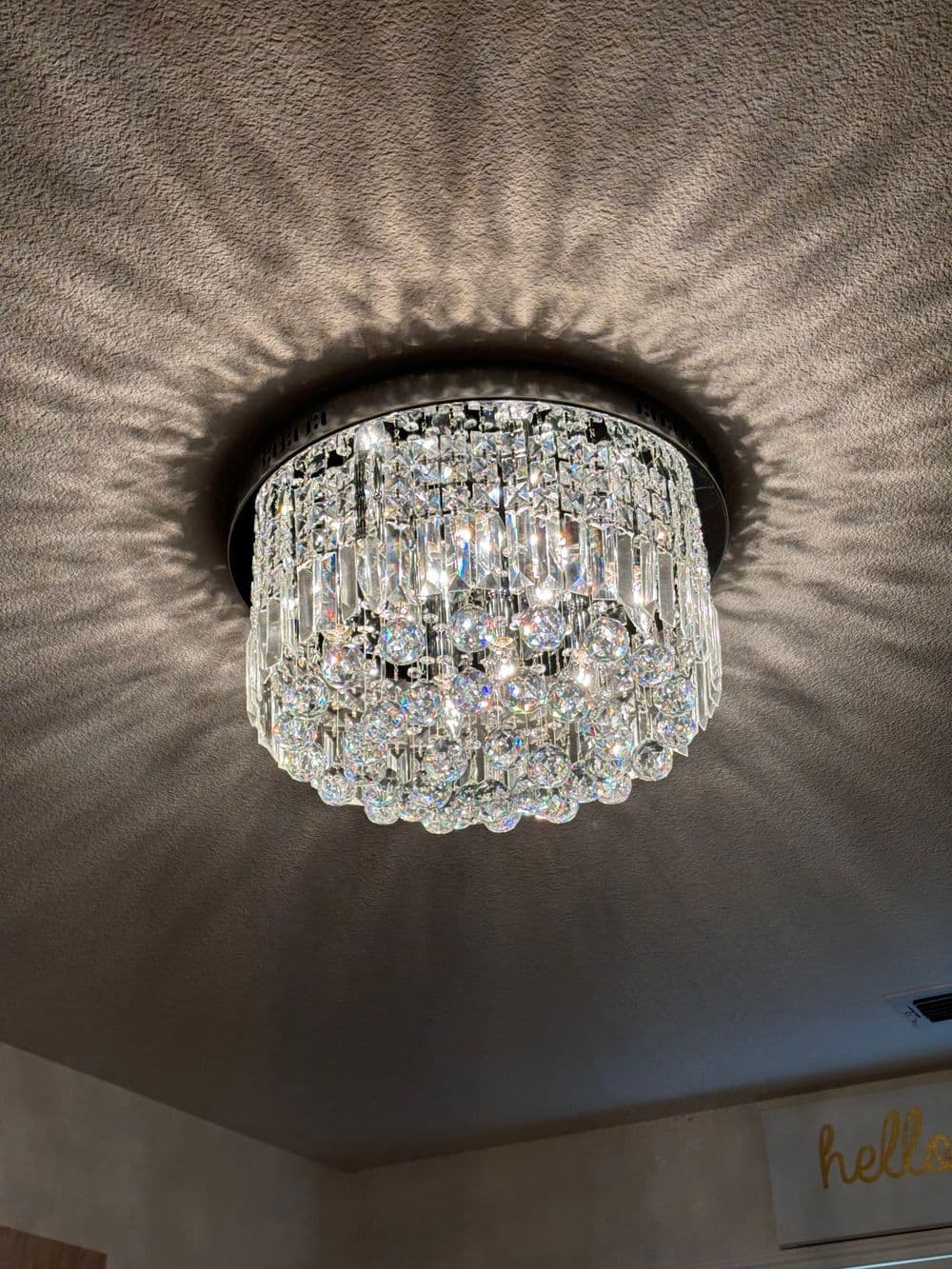 Modern crystal chandelier casting intricate shadows on a ceiling. Elegant lighting fixture.
