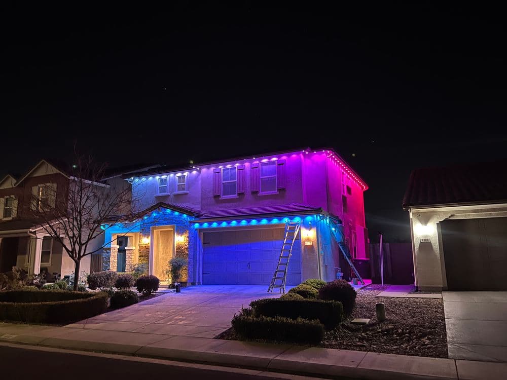House decorated with colorful lights at night, showcasing festive spirit and holiday cheer.