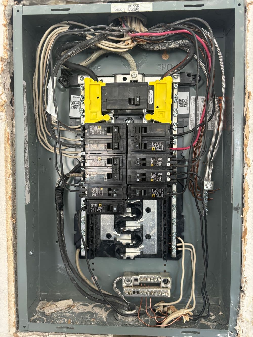 Electrical panel with circuit breakers and wiring, showcasing organized power distribution.
