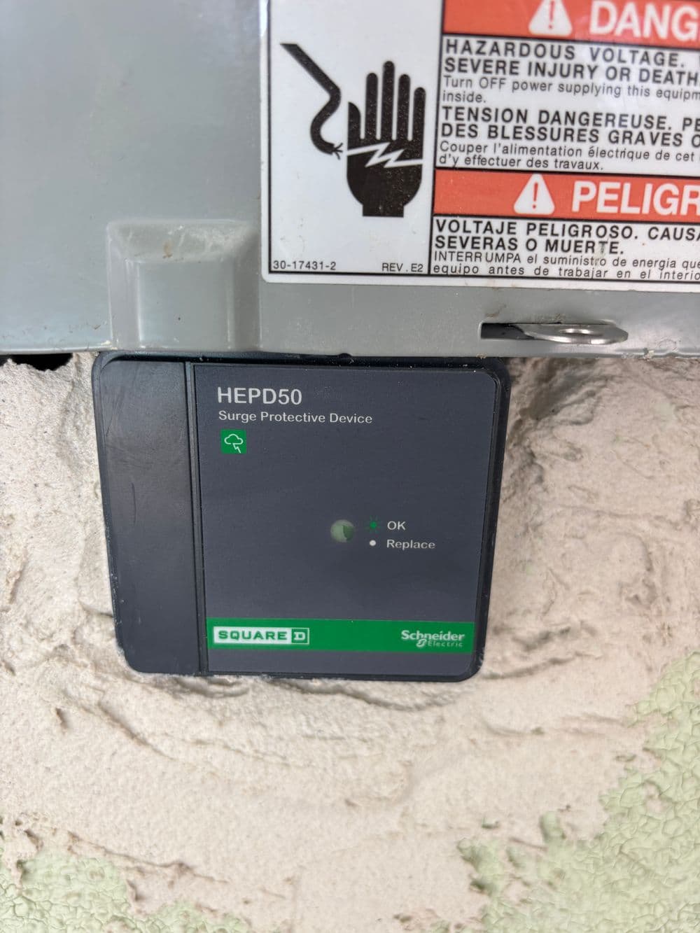 Square D HEPD50 Surge Protective Device installed, indicating power status with 'OK' light.
