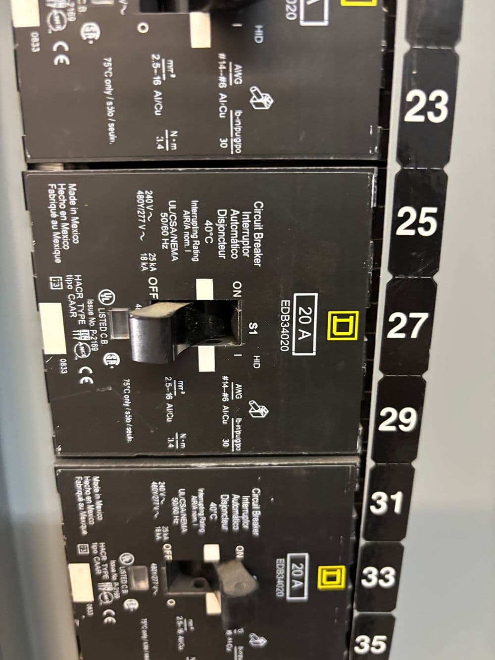 Electrical panel with circuit breakers labeled 20A, 23, 25, 27, and 29 for safe power distribution.