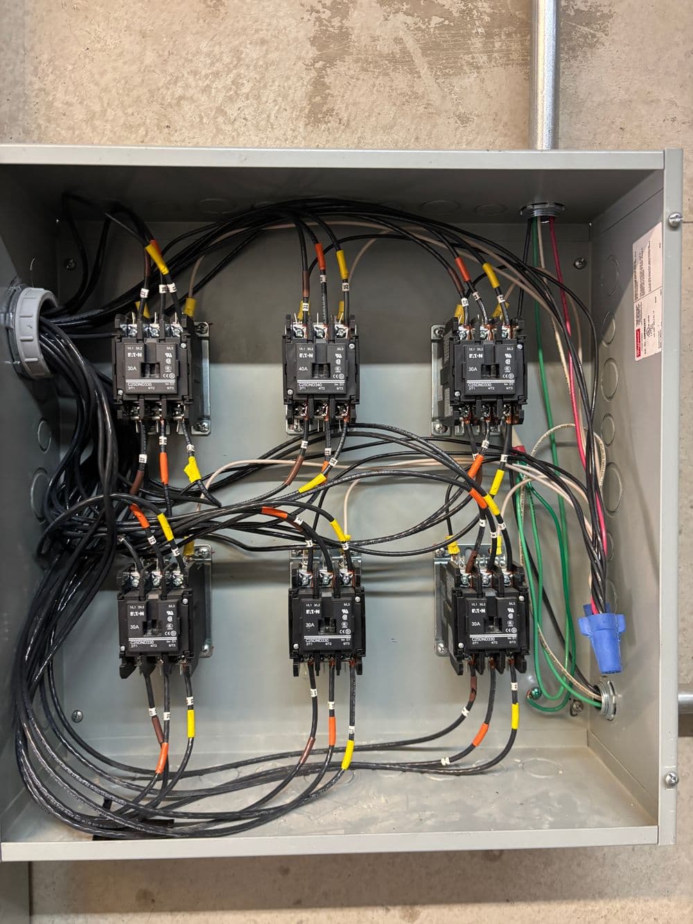Electrical control panel with multiple relays and organized wiring connections.